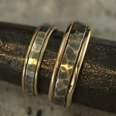 Bands Mixed Metal Rings Rustic Wedding Bands Mens Wedding Rings Womens Wedding Bands Two Tone Rings Hammered Wedding Set Paragon Blazer Arts Our Paragon Design is one of our most popular. It's rugged yet elegant, and now we have the perfect set for a couple who can be described that same way. To create your bands we will first securely solder full round 14K gold stock to both sides of a piece of rectangular silver stock. We then hand form this joined material into a ring just for you. The 14K go Silver Hammered Wedding Jewelry, Hammered Silver Jewelry For Wedding, Handmade Yellow Gold Stackable Wedding Rings, Handmade Gold Stackable Rings For Wedding, Adjustable Stackable Wedding Jewelry, Adjustable Stackable Jewelry For Wedding, Handmade Yellow Gold Wedding Rings, Adjustable Wedding Ring Jewelry, Handmade Elegant Couple Rings For Wedding