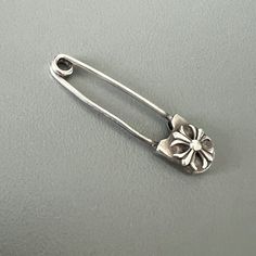 a close up of a metal object on a gray surface with a flower in the center