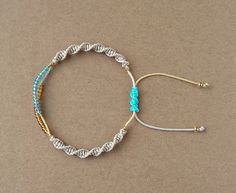 two bracelets with blue beads and gold accents on a brown surface, one is made out of rope