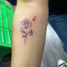 a small flower tattoo on the left thigh and right leg, with a butterfly flying over it