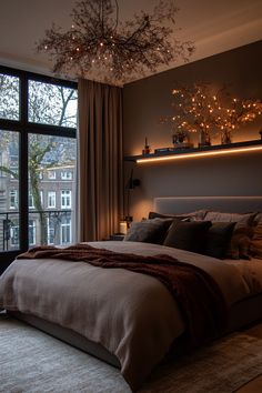 a bedroom with a large bed and lights on the headboard, along with a chandelier