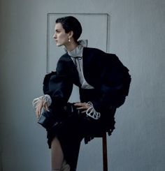 a woman sitting on top of a wooden chair