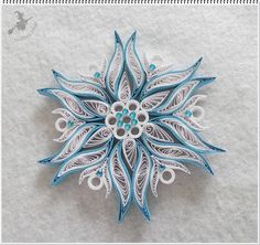 an intricate paper snowflake with blue and white accents