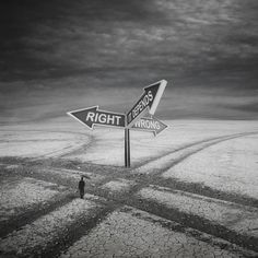 a man standing in the middle of a desert with two signs that say right and wrong