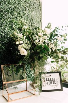 a vase filled with white flowers sitting on top of a table next to a mirror