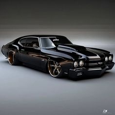 a black muscle car with gold rims parked in a dark room next to a wall