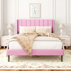 a bed with pink headboard and pillows in a white walled room, along with two lamps on either side of the bed