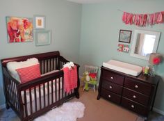 a baby's room with two cribs, dresser and pictures on the wall