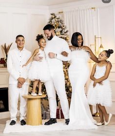 a family posing for a photo in front of a christmas tree