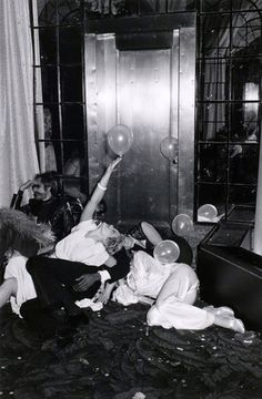 an old black and white photo of people in a room playing with bubbles on the floor