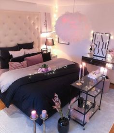 a bedroom decorated in black and white with candles on the bed, nightstands and other decorations