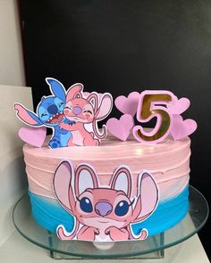 a cake with pink frosting and cartoon characters on it