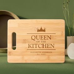 a cutting board with the queen of the kitchen engraved on it