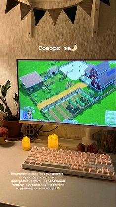 a computer screen with an image of a farm on the monitor and some plants in front of it