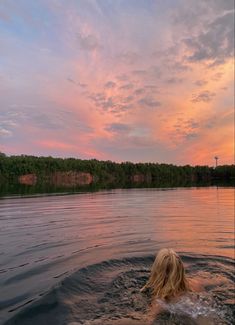 a person swimming in the water at sunset