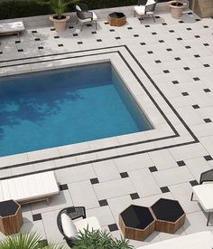 an aerial view of a swimming pool and patio furniture