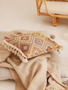 a pile of blankets sitting on top of a white floor next to a wooden chair