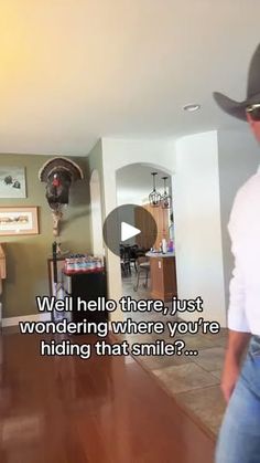 a man wearing a cowboy hat standing in front of a living room filled with furniture