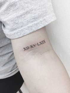 a woman's arm with roman numerals tattooed on the left inner arm