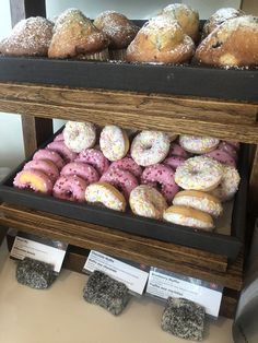 a display case filled with lots of different kinds of doughnuts and muffins