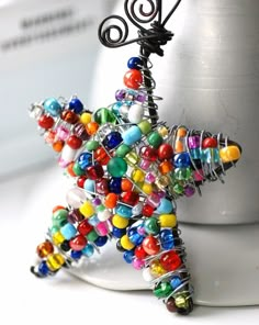 a multicolored beaded star ornament sitting on top of a computer keyboard