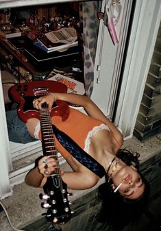 a woman laying on the ground with a guitar