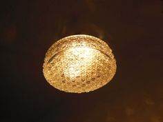 a light that is hanging from the ceiling in a dark room with some lights on