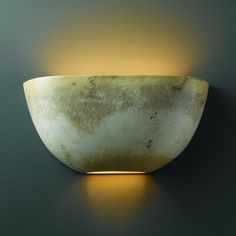 a light that is on the side of a wall with a bowl in front of it