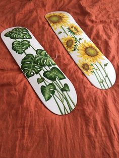 two sunflowers are painted on the side of an ironing board