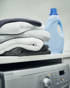 stack of folded towels sitting on top of a dryer