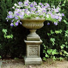 a stone urn with purple flowers in it