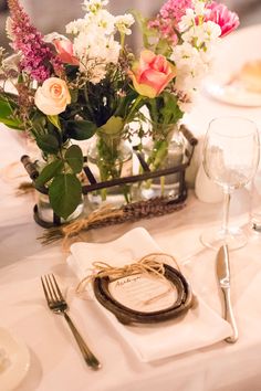 the table is set with flowers and place settings