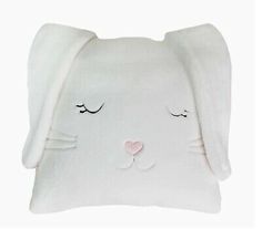 a white bunny pillow with eyes closed