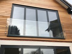 a dog is looking out the window of a wooden house with glass panes on it