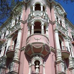 an ornate pink building with white trim and balconies