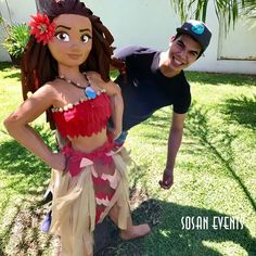 a man standing next to a woman in a hula skirt on top of grass