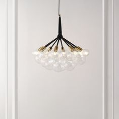 a chandelier hanging from the ceiling in a room with white walls and flooring