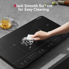 a woman cleaning the surface of a stove top with a cloth on it and ingredients around her