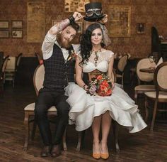 a bride and groom sitting on chairs in a restaurant