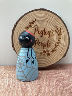 a wooden piece with a spider on it next to a sign that says peace's people