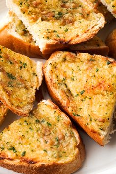 several pieces of bread on a plate with parsley sprinkled on top and one slice cut in half