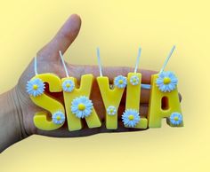 the word sylp is made out of yellow plastic with daisies on it