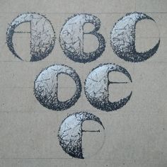 the letters and numbers are drawn with black pencils on a piece of brown paper