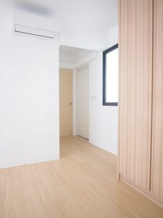 an empty room with white walls and wood floors