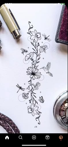 a drawing with flowers and birds on it next to a pen, scissors and other items