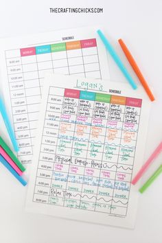 two printable calendars sitting on top of each other next to colored pencils