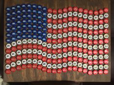 an american flag made out of beer cans on a wooden table with other items around it