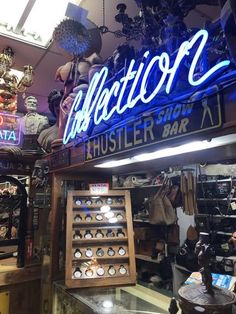 the interior of an antique shop with blue neon signs and other items on display in it