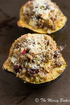 two stuffed acorns sitting on top of a pan covered in cheese and other toppings