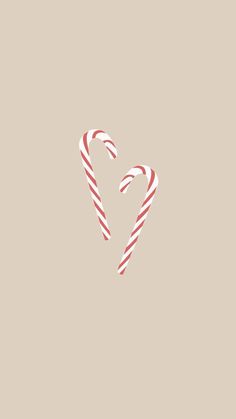 two candy canes in the shape of a heart on a beige background with red and white stripes